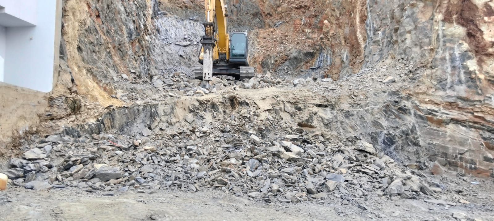Excavadora cortando roca para liberación en García
