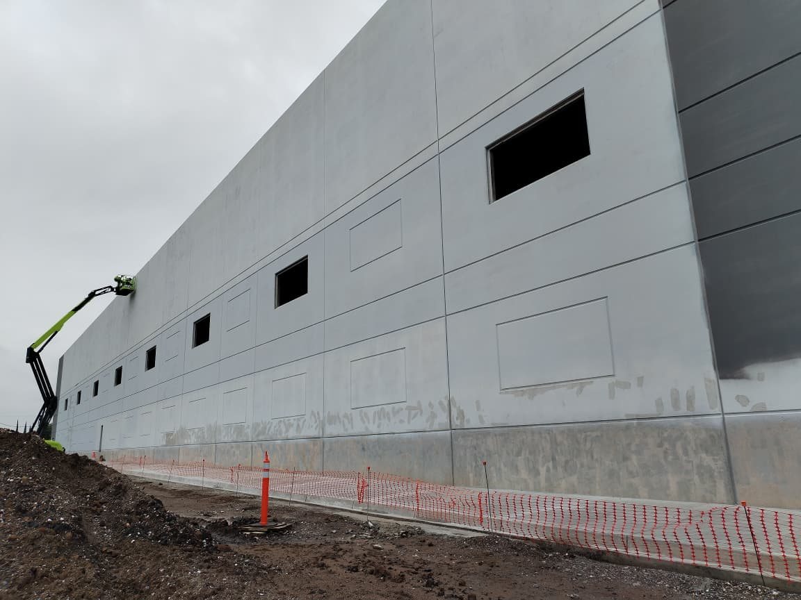 Fachada tilt-up con grúa articulada en obra — proyecto con estrategia de impacto cero CIMTRA Monterrey