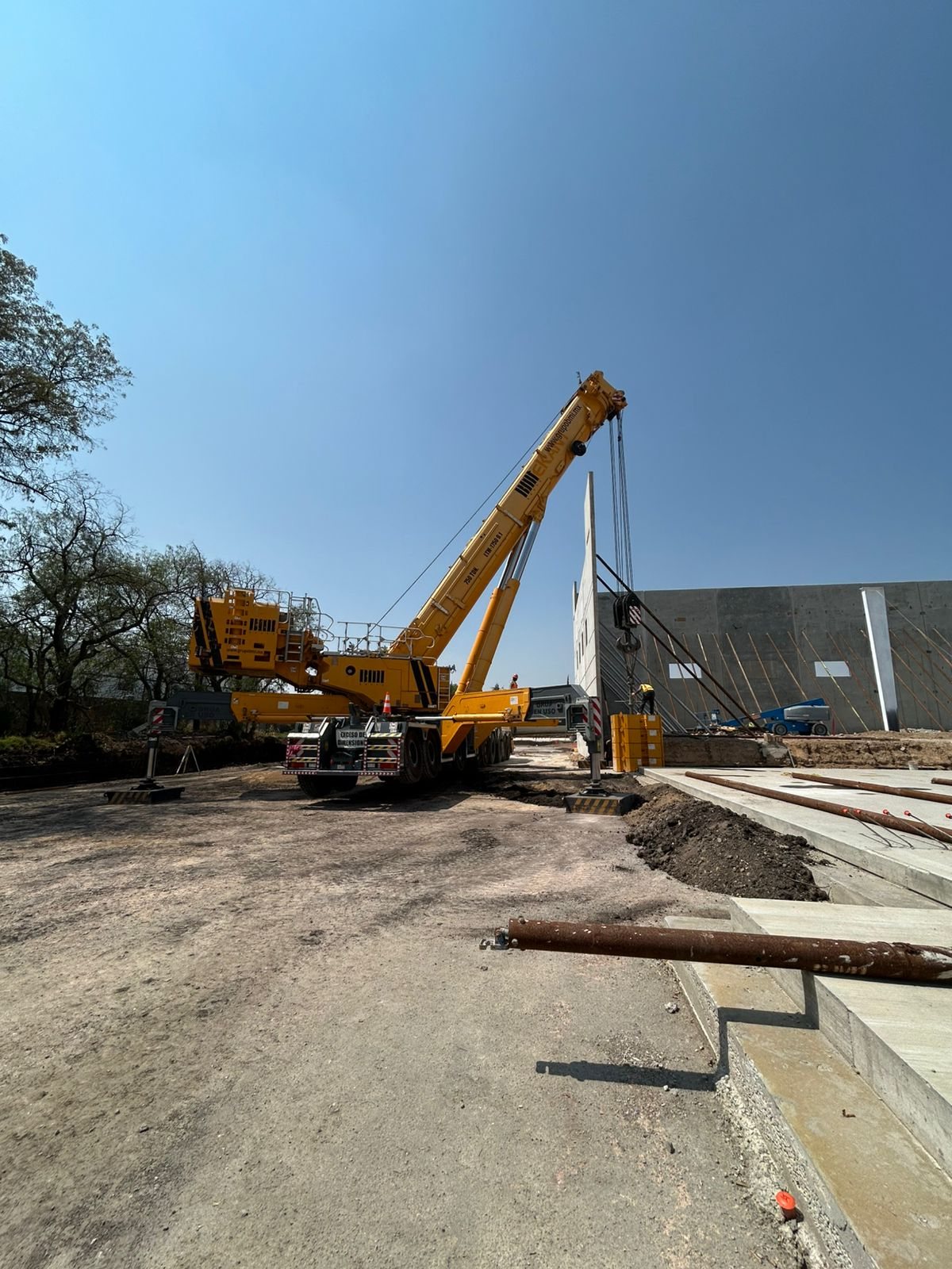 Izaje de muro tilt-up con grúa y camión en obra — proyecto llave en mano CIMTRA