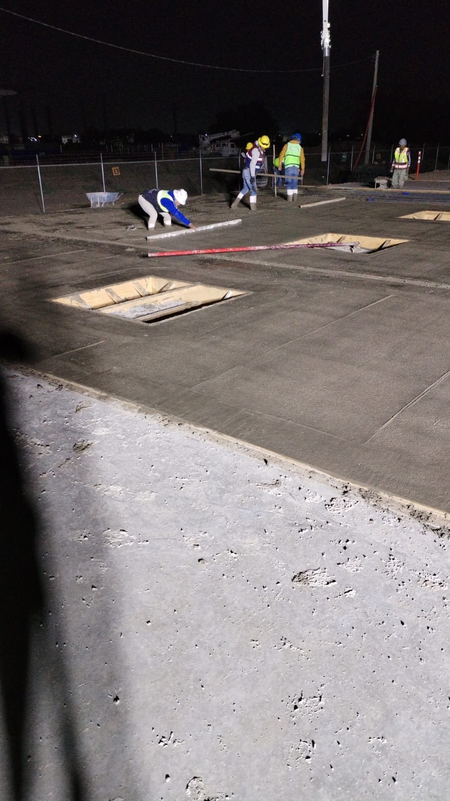 Pavimento hidráulico acabado por cuadrilla en obra nocturna — diseño vial CIMTRA Monterrey