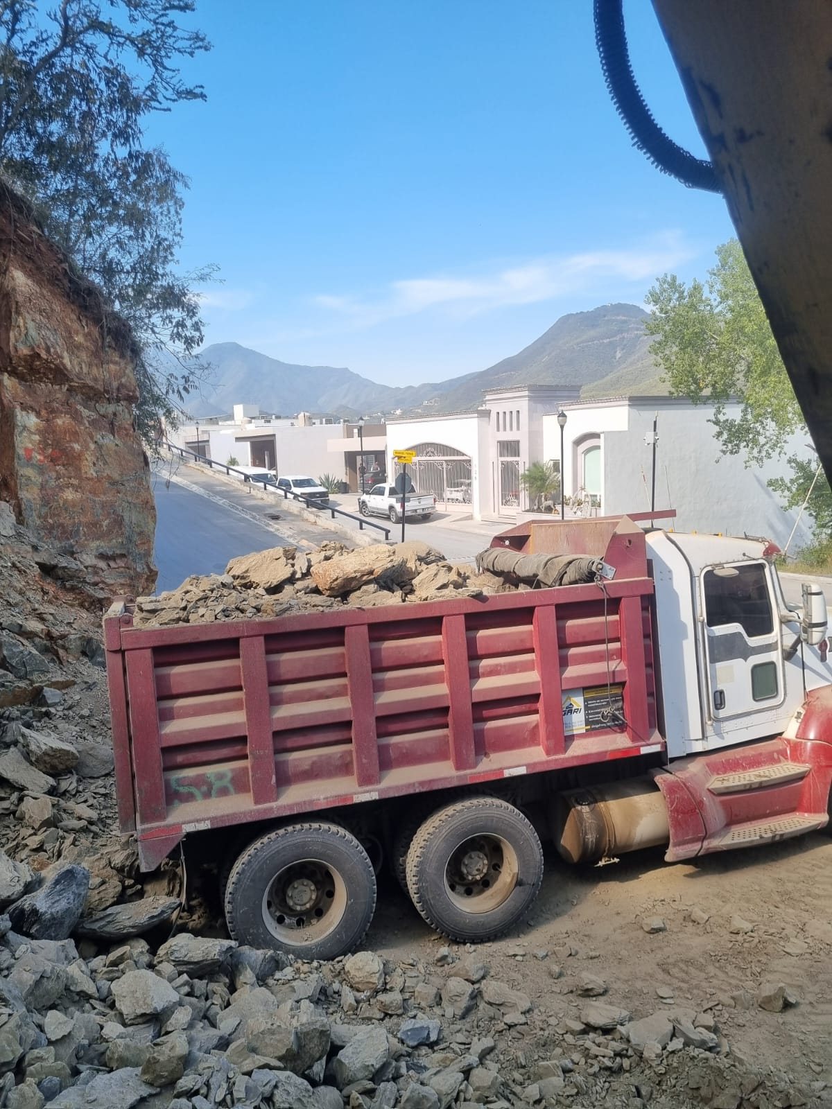 Camión de volteo descargando en obra