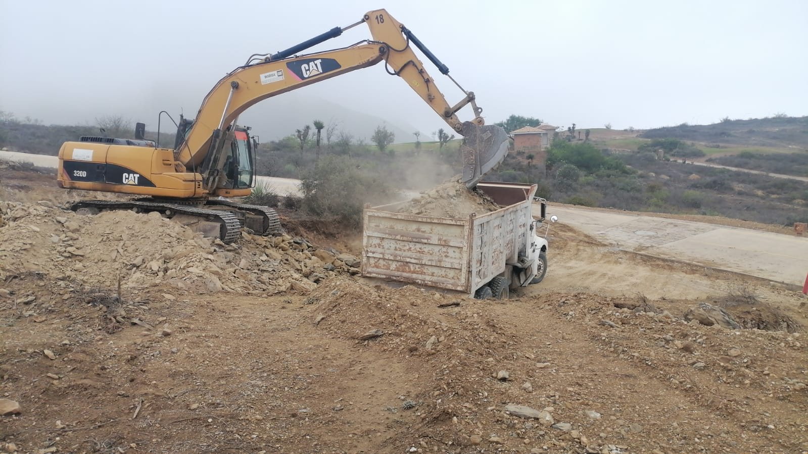 Excavadora CAT cargando camión de volteo en Escobedo